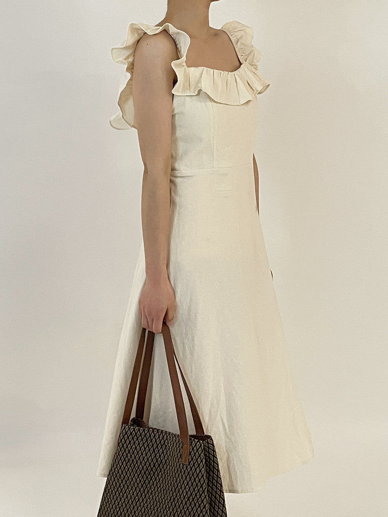 Beige long dress with a slit in the middle and spaghetti straps, suitable for wearing in summer.